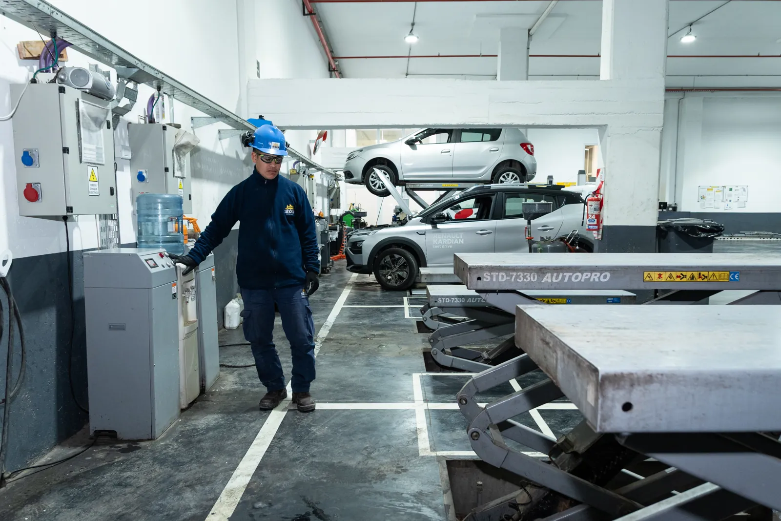 Técnico operando elevadores de autos en una cochera